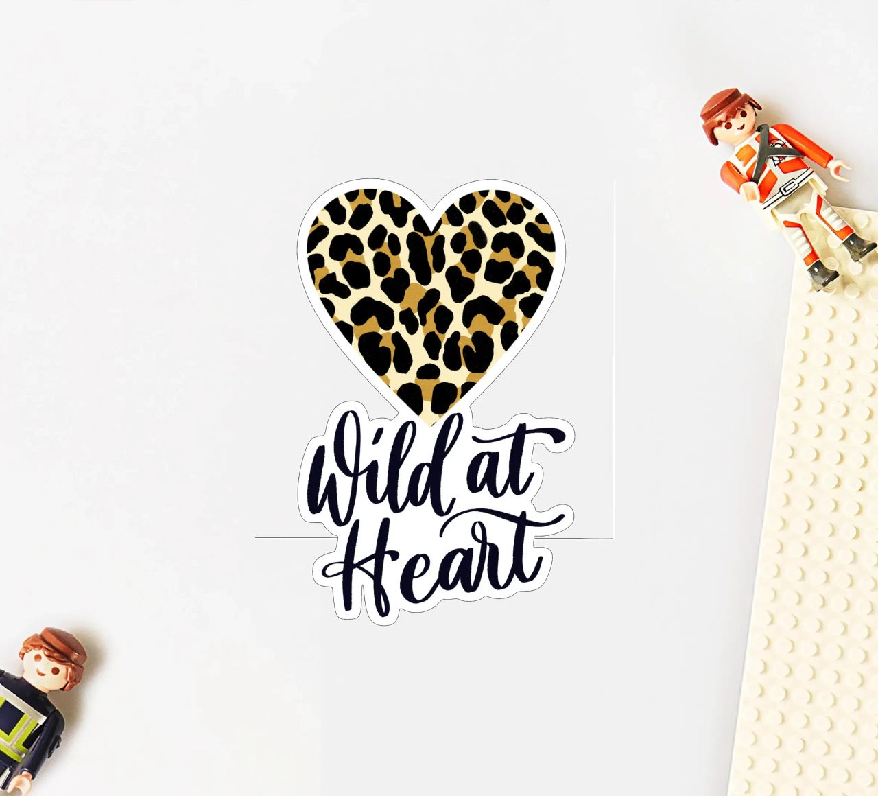 Wild at heart (sauvage au cœur). Slogan avec cœur à motif léopard autocollant de CalliLetters
