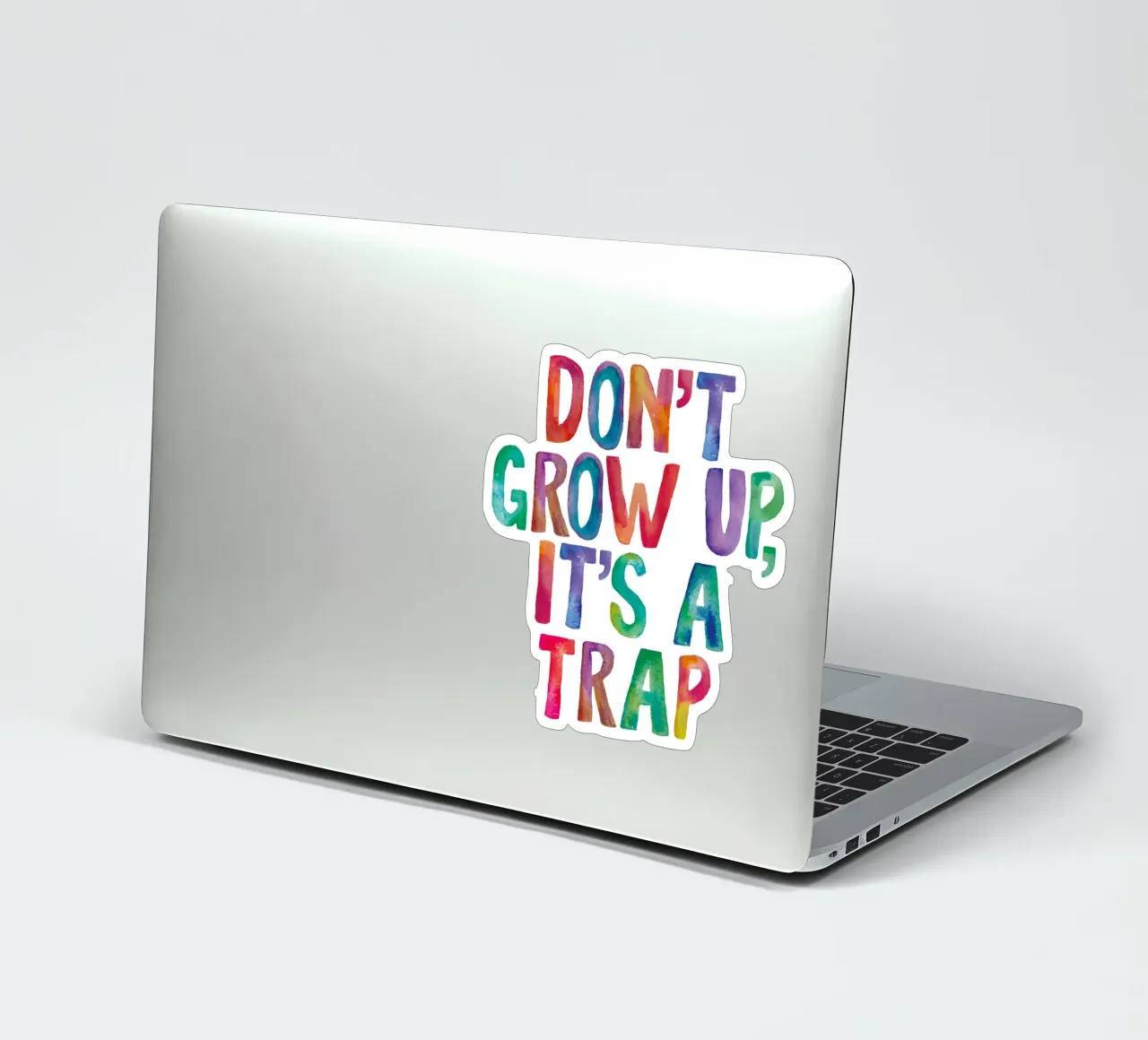 Non crescere è una trappola Design tipografico arcobaleno adesivo da THE MOTIVATED TYPE