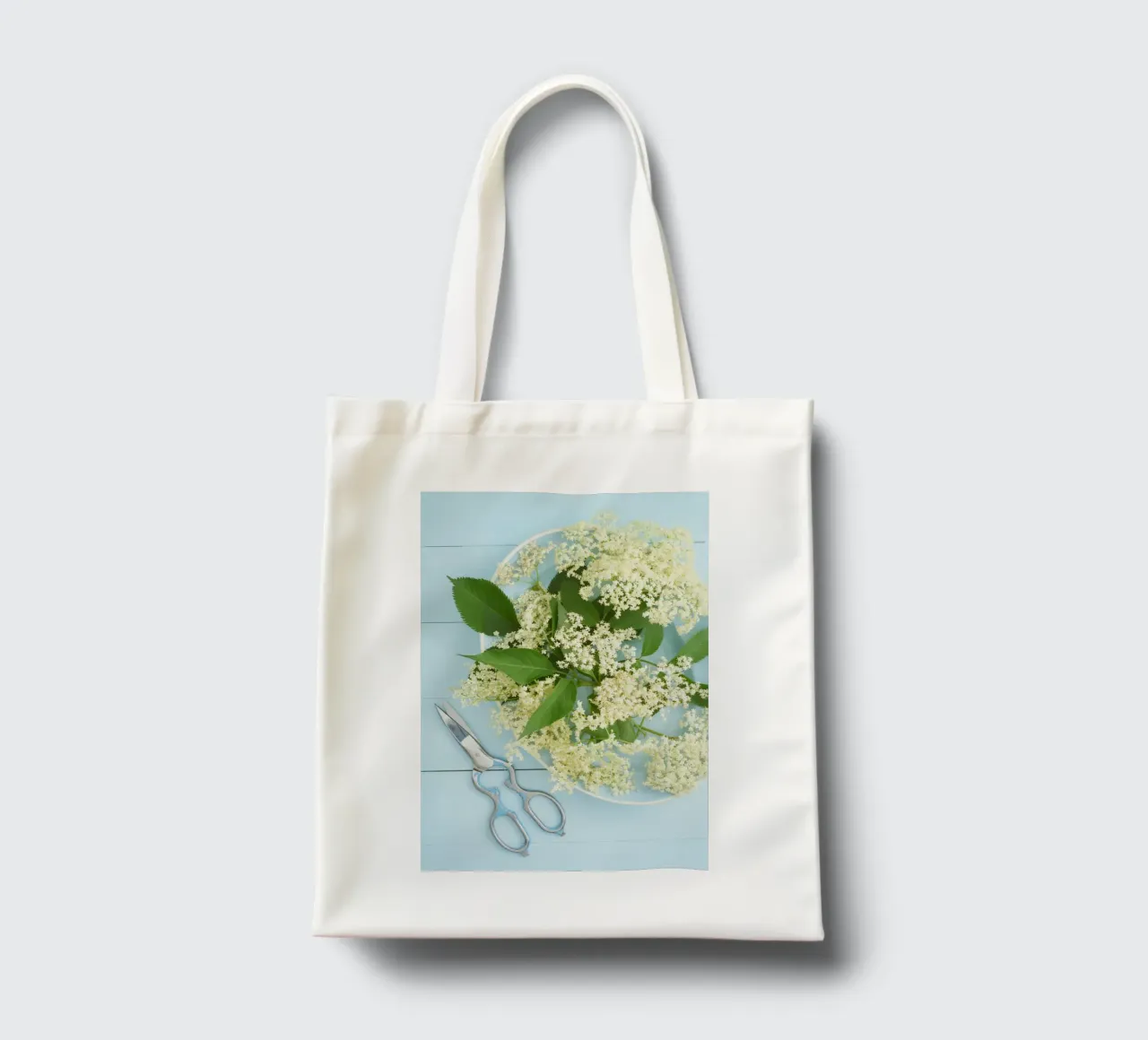 Raccolta di fiori di sambuco su tavolo blu rustico borsa in juta da foodphotolove