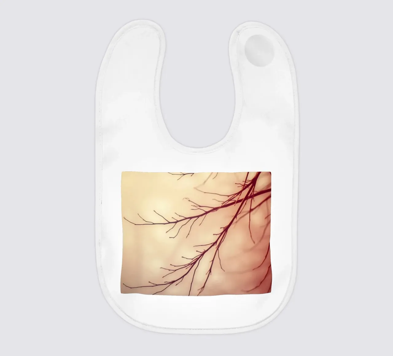 ein sanft verschwommener Hintergrund mit anmutigen Baumzweigen Babylätzchen von DesignDoodle