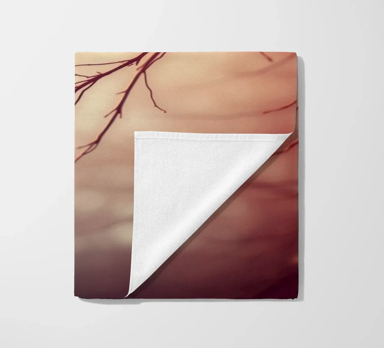 a softly blurred background with graceful tree branches beach towel by DesignDoodle