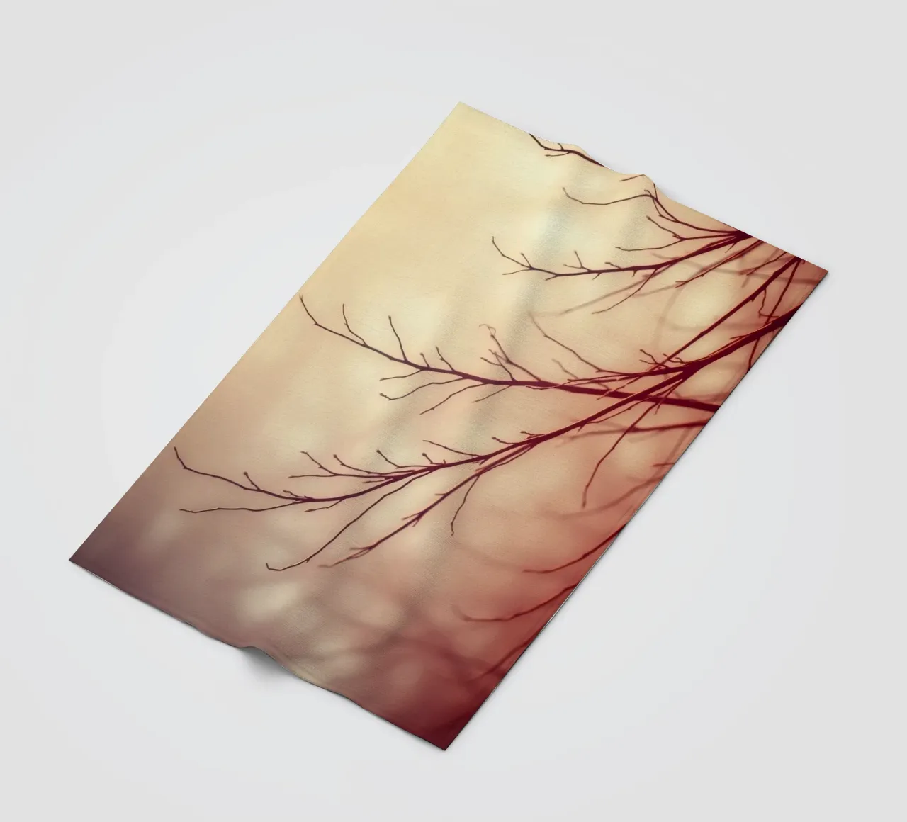 a softly blurred background with graceful tree branches fleece blanket by DesignDoodle