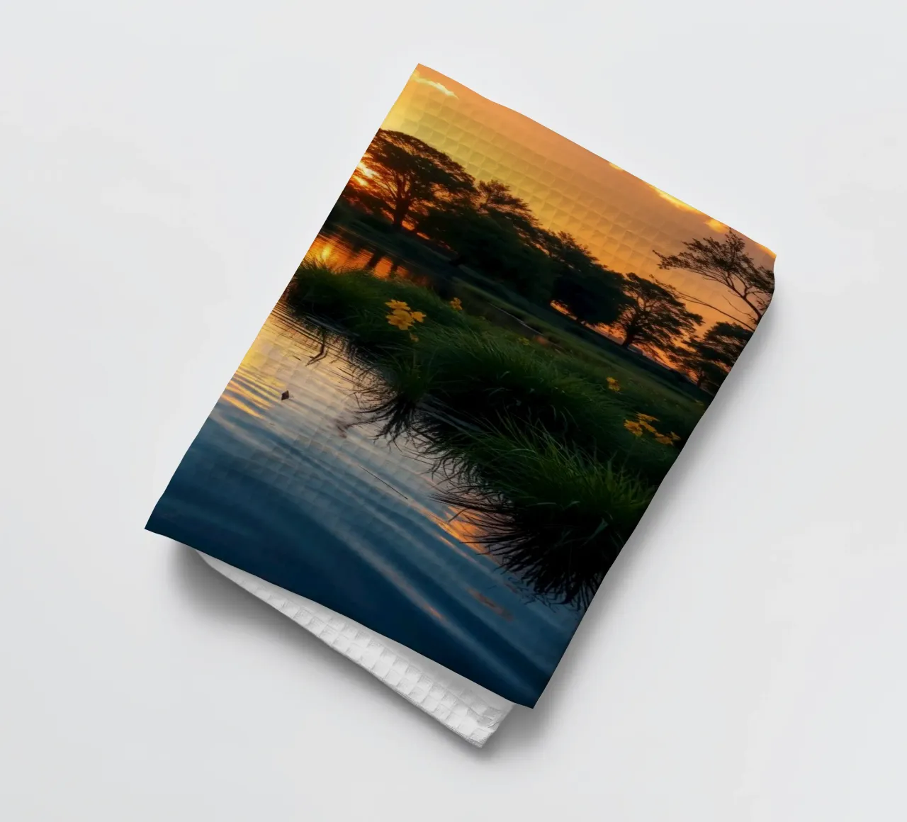 Coucher de soleil éclatant se reflétant sur une eau calme avec des fleurs éclatantes torchon de DesignDoodle