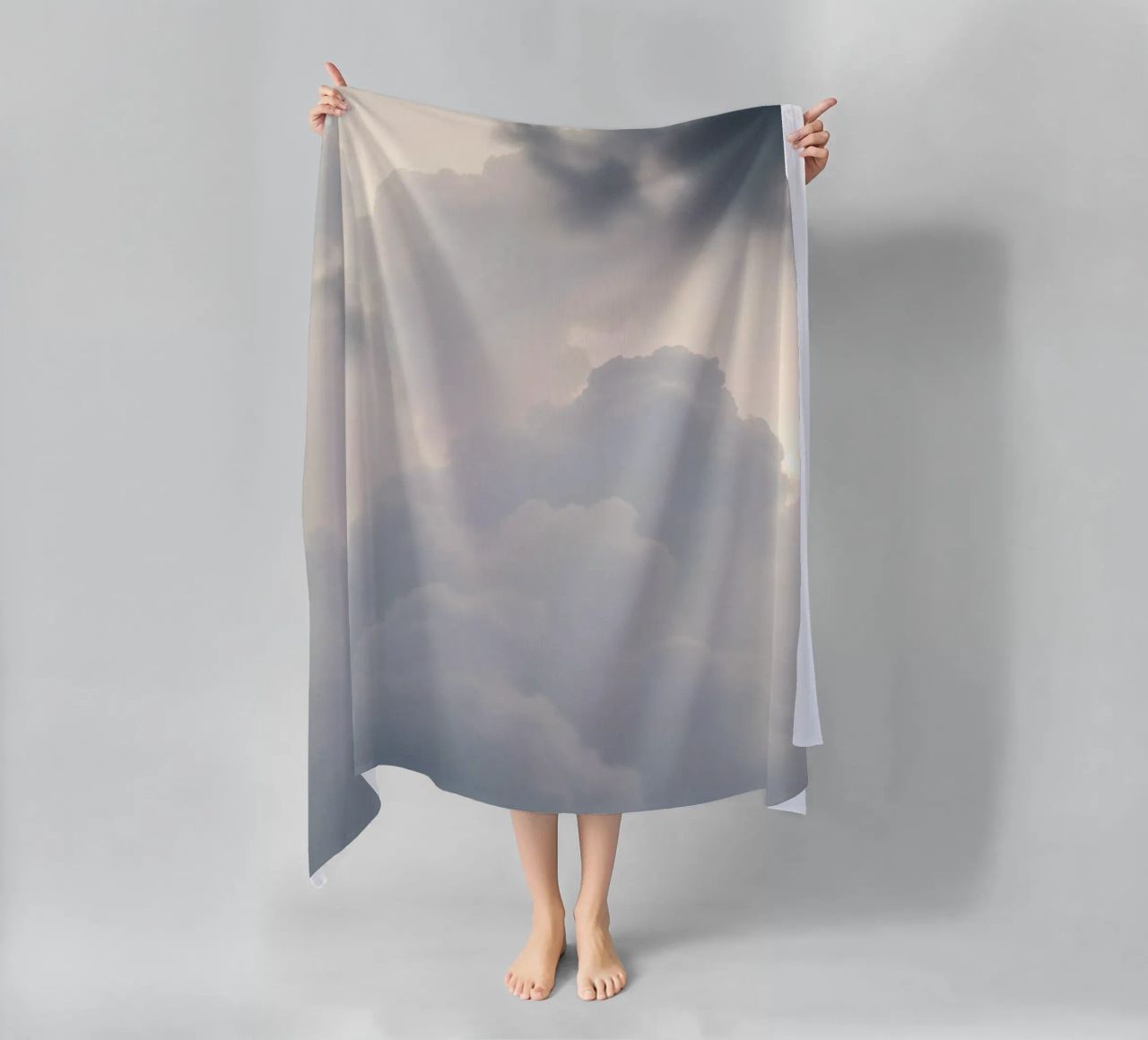 Sky filled with soft clouds and light hues a calm and sooth beach towel by DesignDoodle