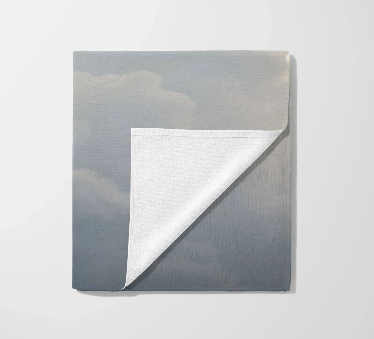 Sky filled with soft clouds and light hues a calm and sooth beach towel by DesignDoodle