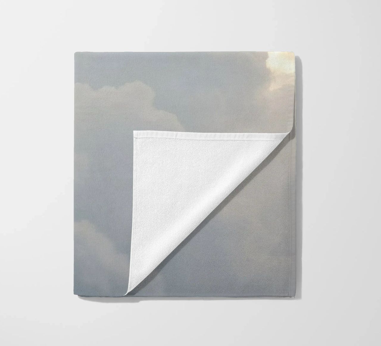 Sky filled with soft clouds and light hues a calm and sooth beach towel by DesignDoodle