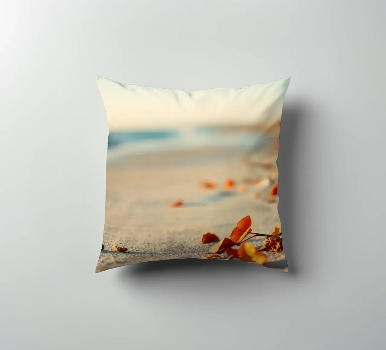 Foglie d'autunno sparse sulla spiaggia sabbiosa al tramonto cuscino da DesignDoodle