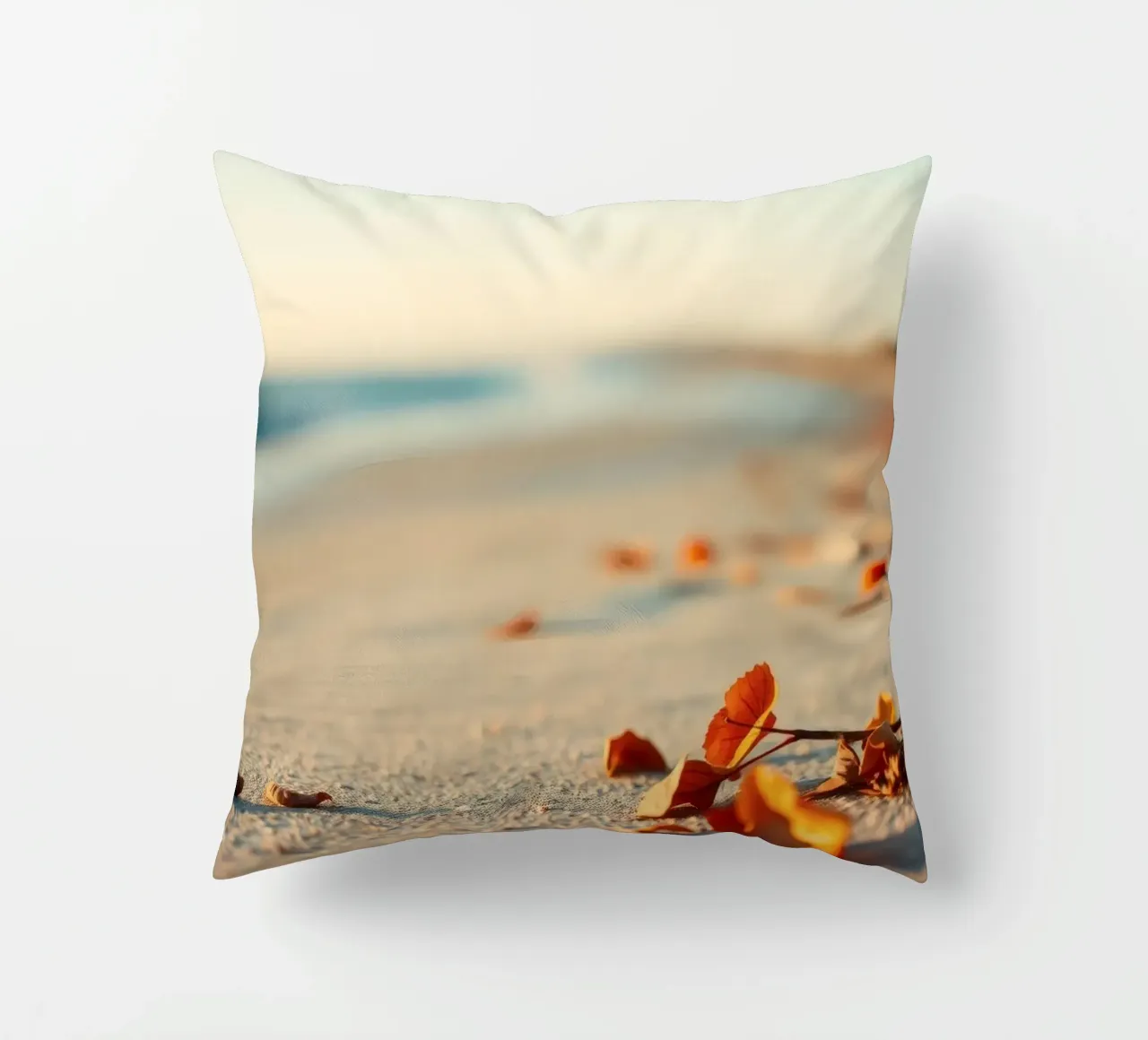 Foglie d'autunno sparse sulla spiaggia sabbiosa al tramonto cuscino da DesignDoodle