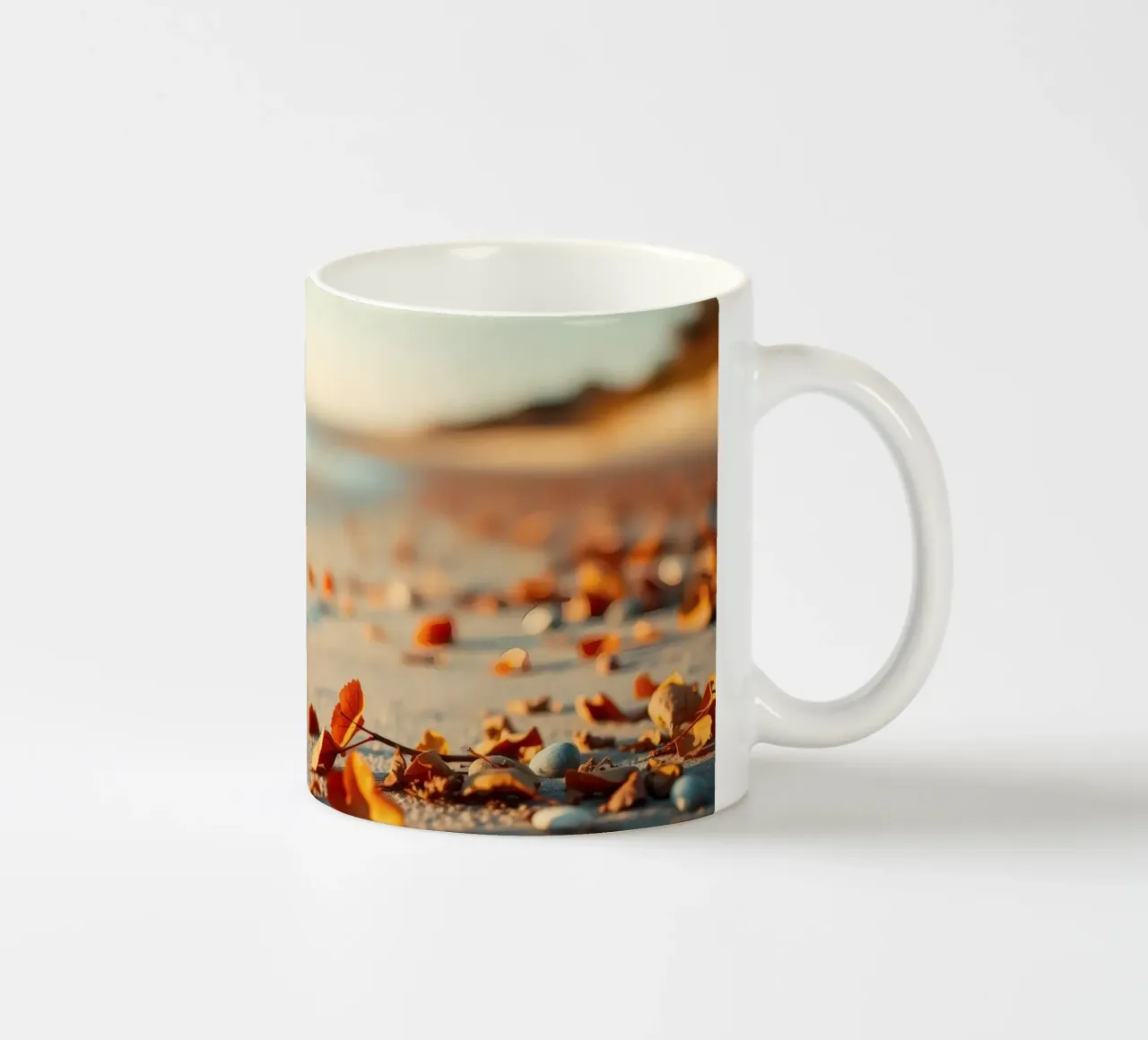 Foglie d'autunno sparse sulla spiaggia sabbiosa al tramonto tazza in ceramica da DesignDoodle