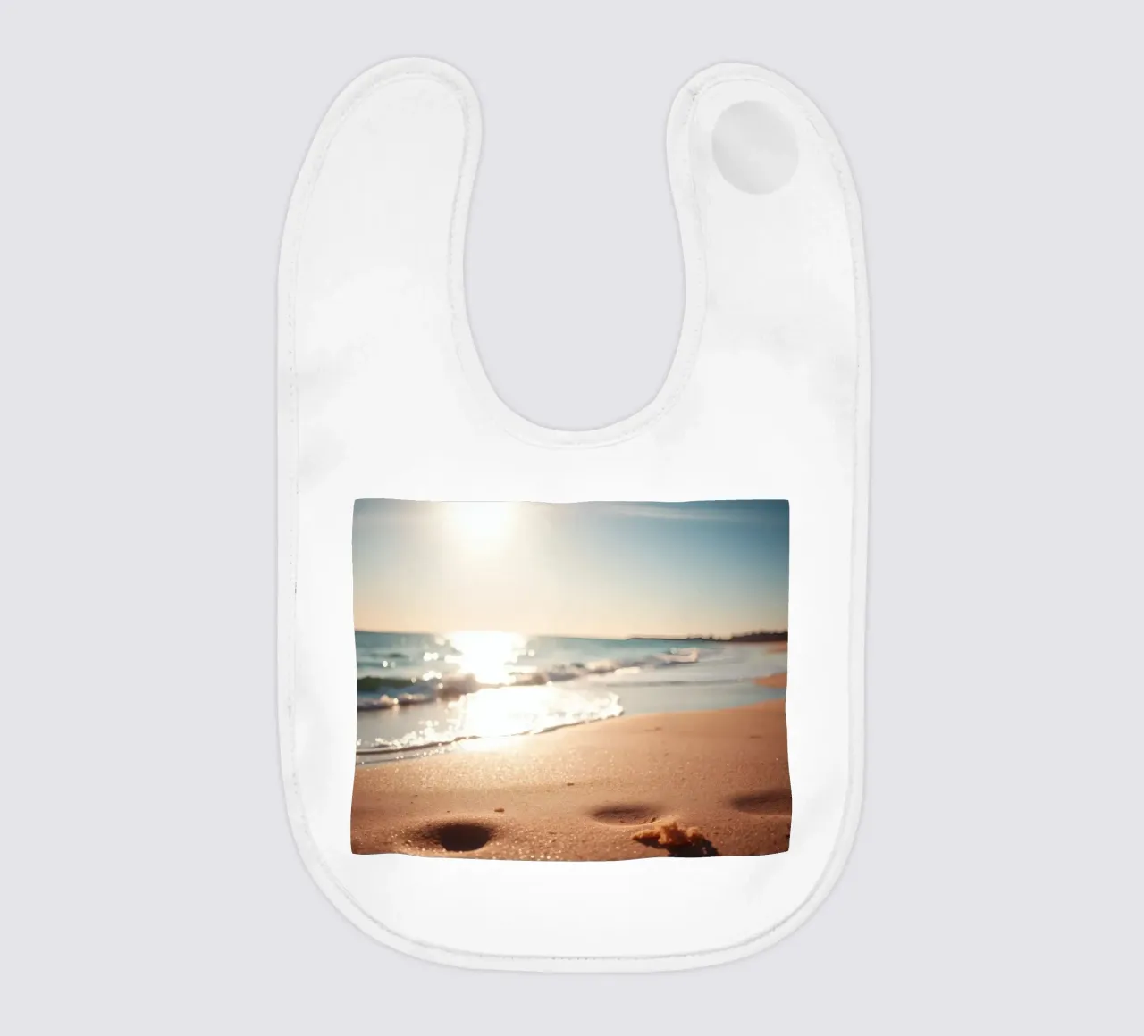 Tramonto su una spiaggia tranquilla con sabbia dorata e dolci onde bavaglino da DesignDoodle