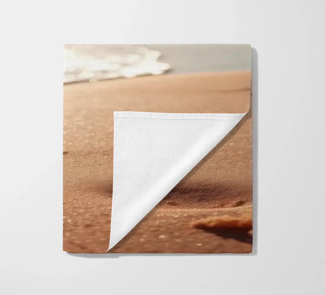 Zonsondergang over rustig strand met goudkleurig zand en zachte golven strandhanddoek van DesignDoodle