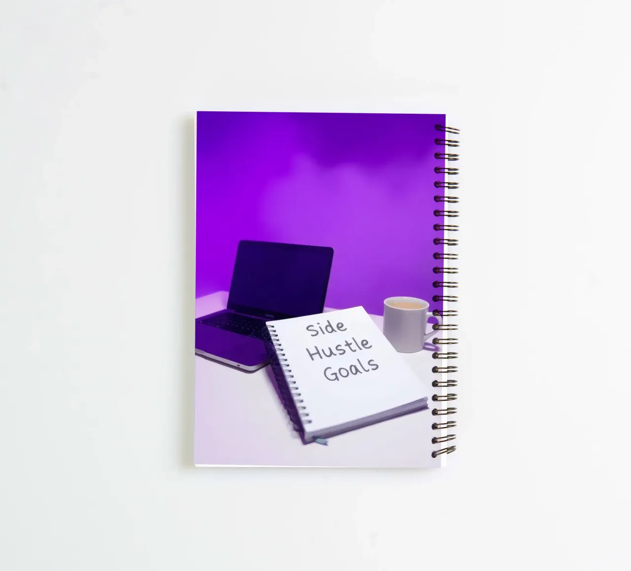 Setting side hustle goals with a laptop and coffee in a cozy spiral notebook by DesignDoodle