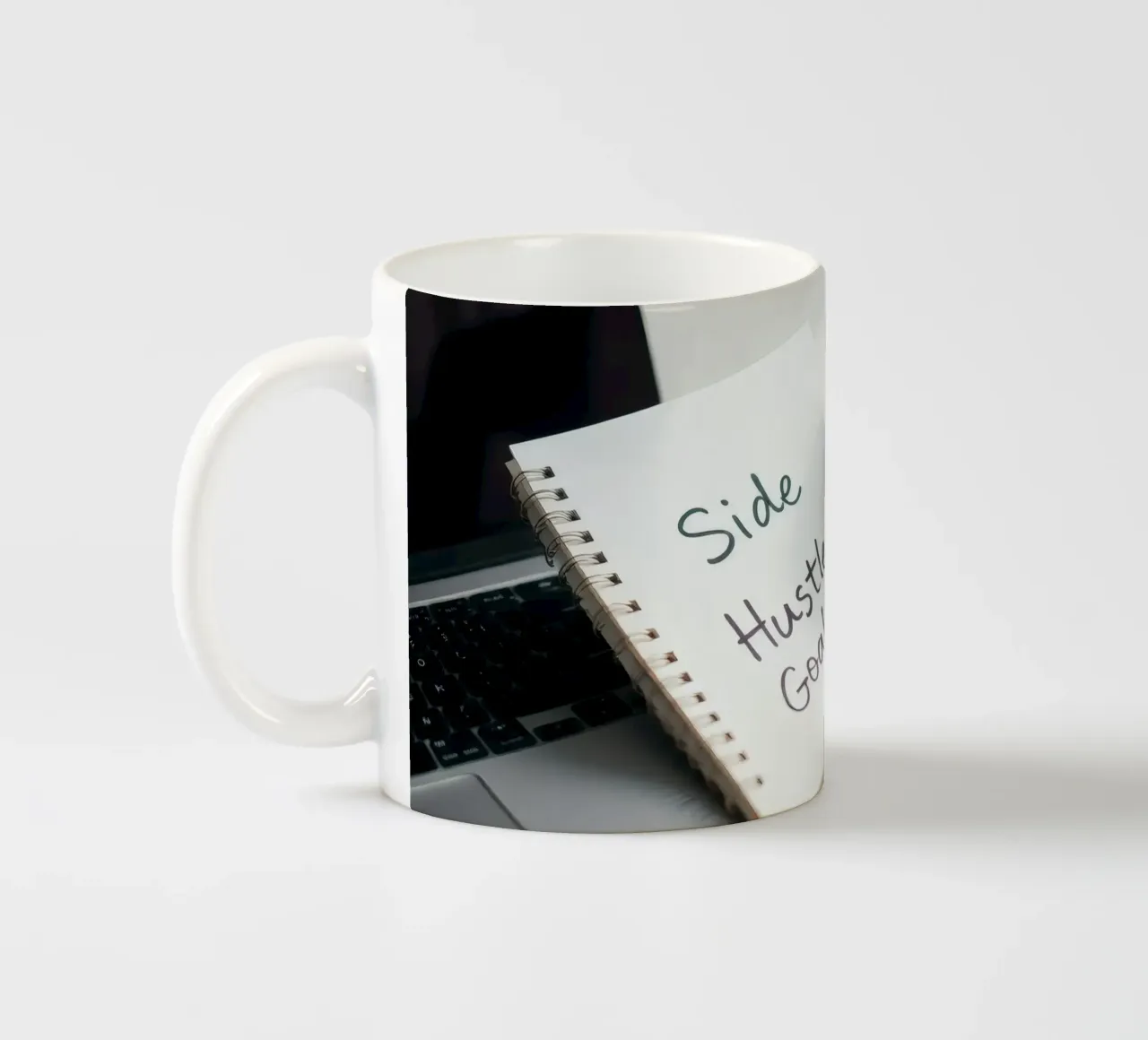 Scrivere gli obiettivi del side hustle mentre si gusta un caffè tazza in ceramica da DesignDoodle