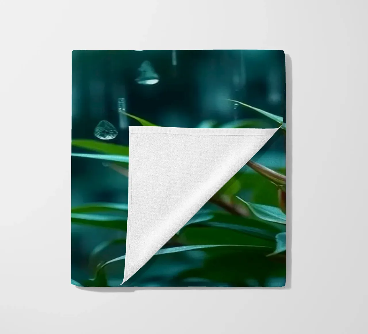 Une pluie douce tombe sur les feuilles vertes d'un jardin luxuriant. serviette de plage de DesignDoodle