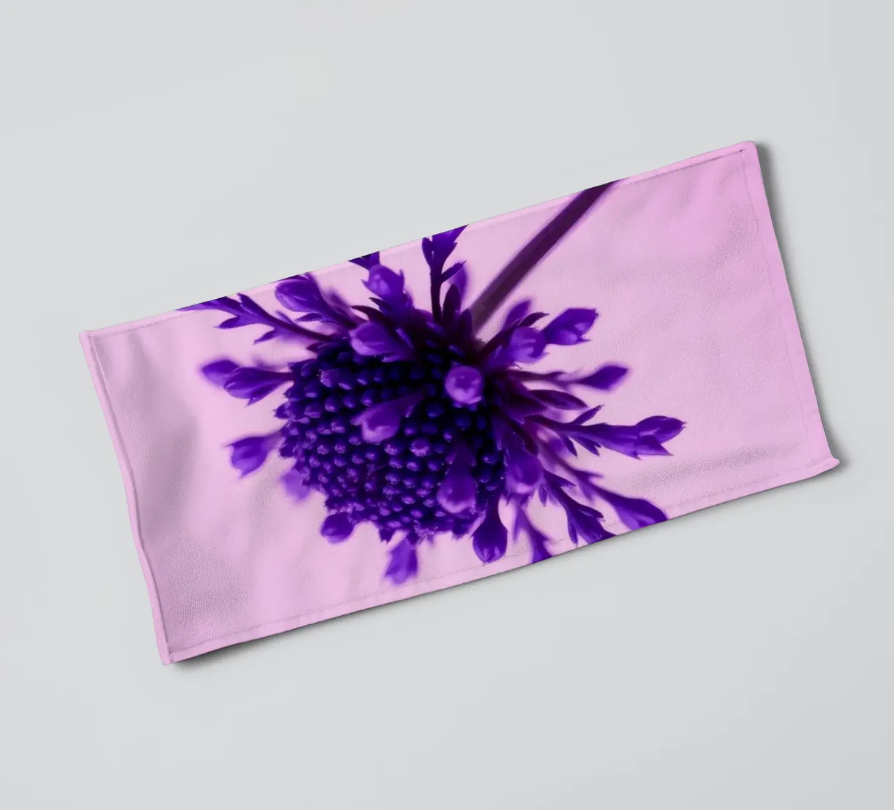 Purple flower stands against a soft pink background towel by DesignDoodle