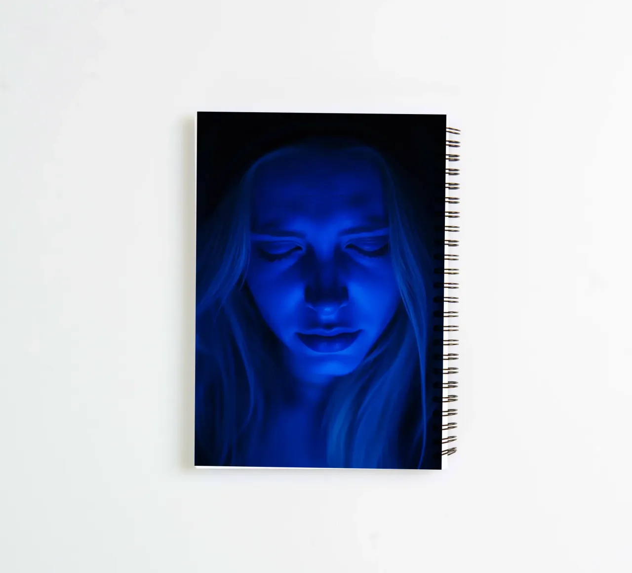 Donna con luce blu incandescente in introspezione in una stanza buia diario ad anelli da DesignDoodle