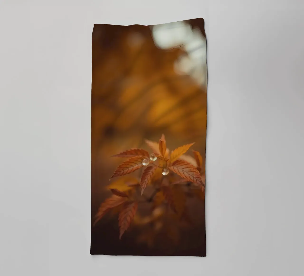 Le foglie autunnali scintillano con le gocce di pioggia in una foresta serena asciugamano da bagno da DesignDoodle
