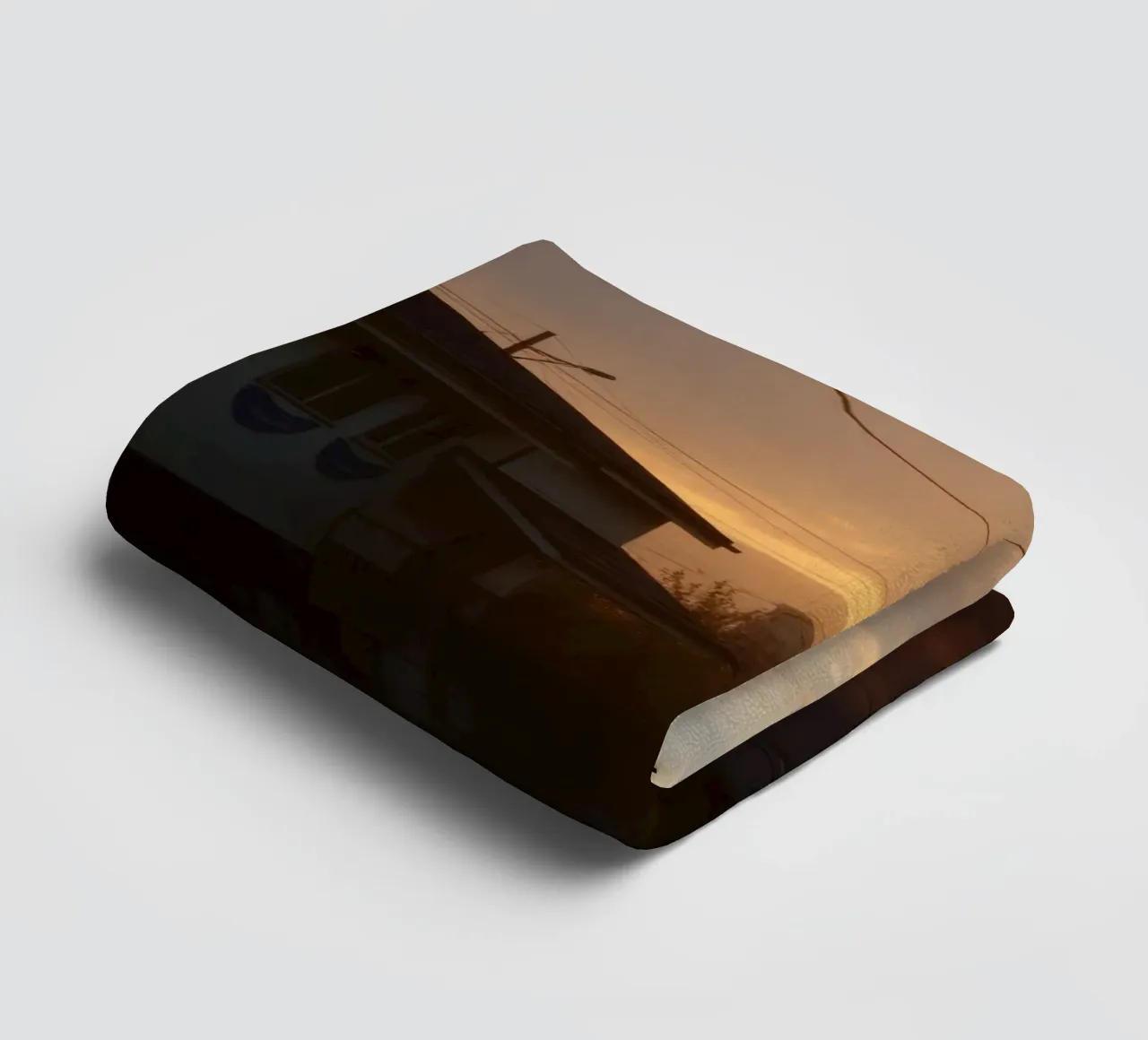 Sunset casts a golden glow over a quiet street lined towel by DesignDoodle