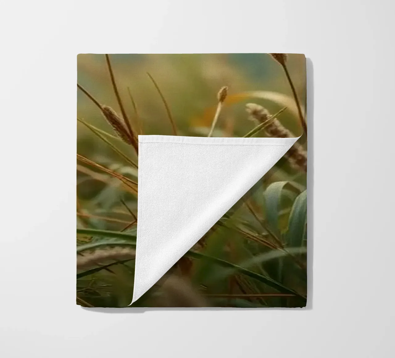 L'herbe dorée se balance doucement dans la brise sur le flanc d'une colline serviette de plage de DesignDoodle