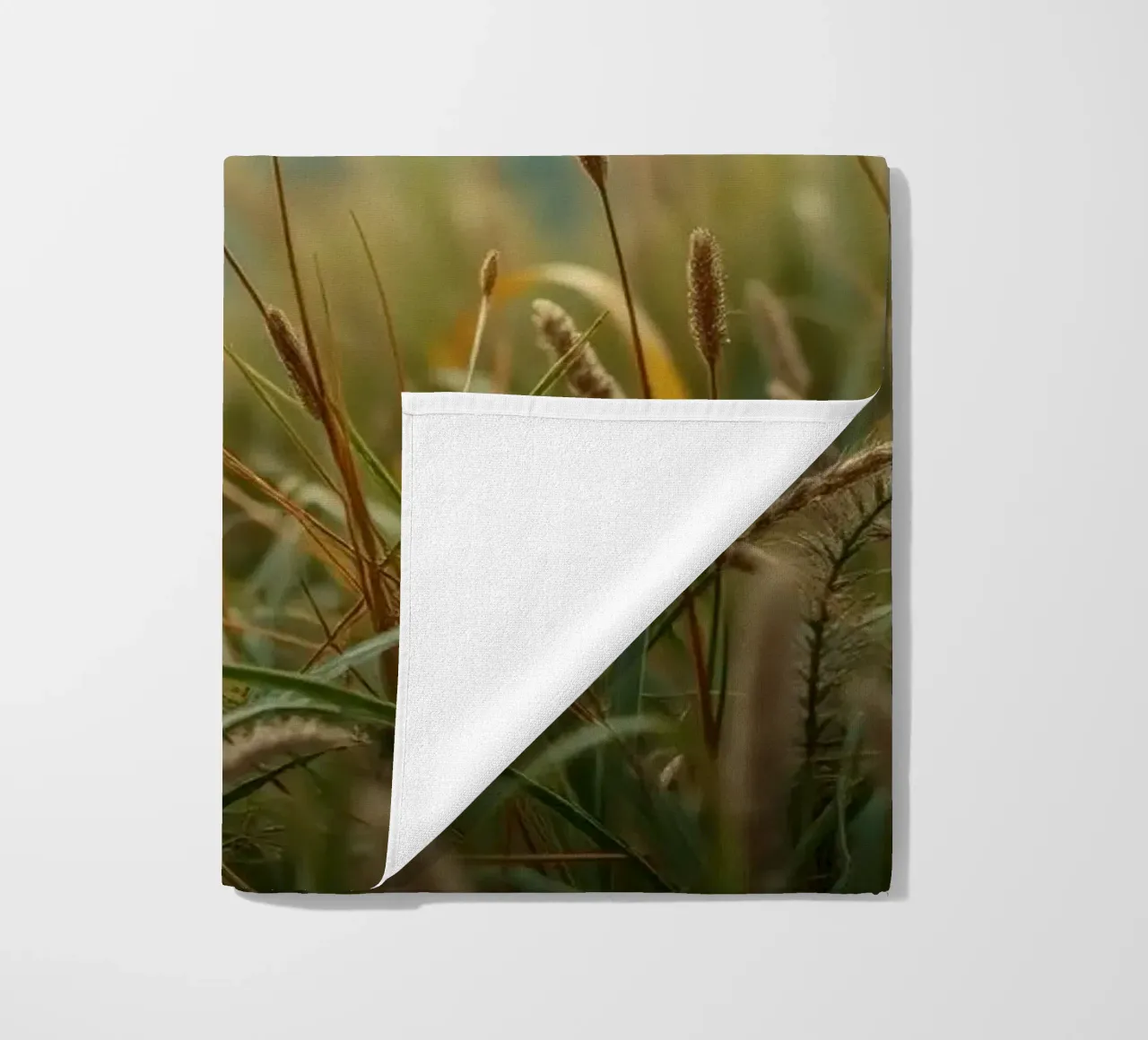 L'herbe dorée se balance doucement dans la brise sur le flanc d'une colline serviette de plage de DesignDoodle