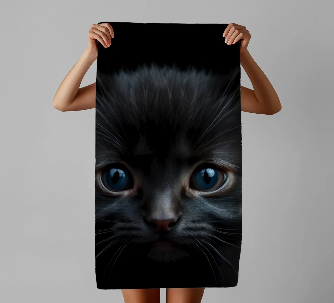 Un mystérieux chaton noir aux yeux bleus saisissants regarde l'intention serviette de bain de DesignDoodle