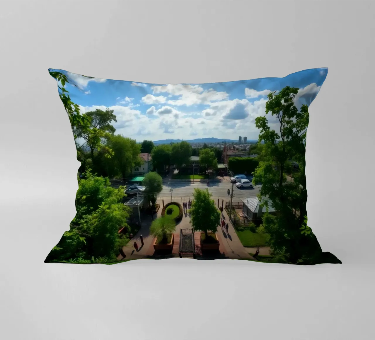 una giornata di sole in un parco verde con sentieri e lo skyline della città cuscino da DesignDoodle