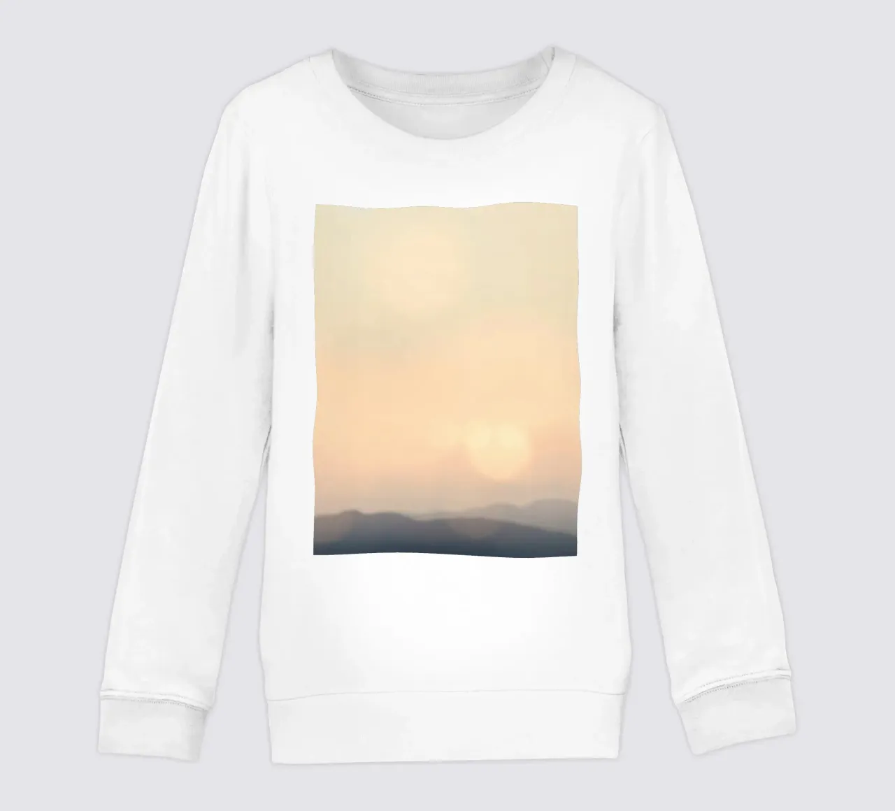 Sunset casting a warm glow over distant mountains and cloude kids sweatshirt by DesignDoodle