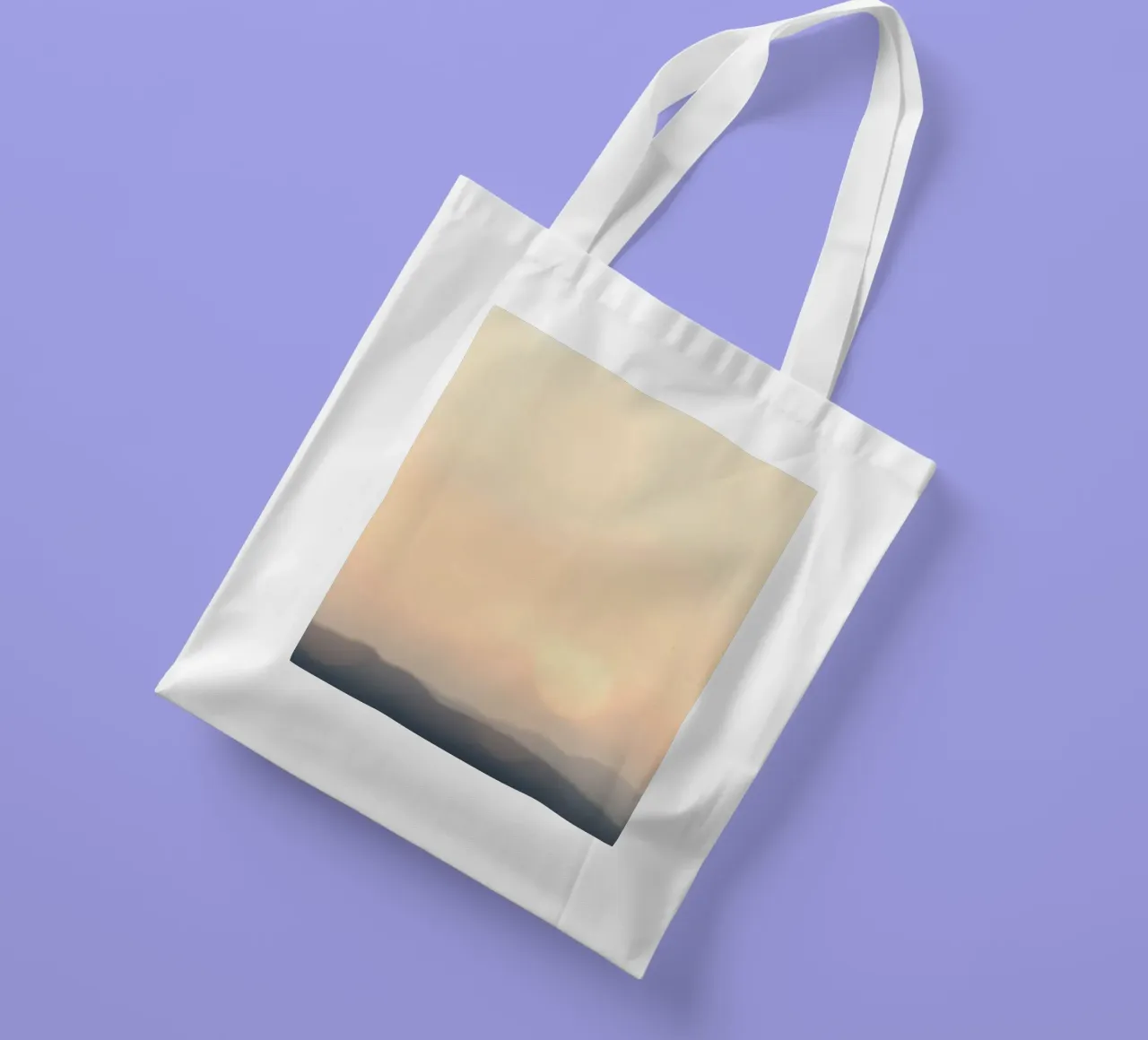 Sunset casting a warm glow over distant mountains and cloude tote bag by DesignDoodle