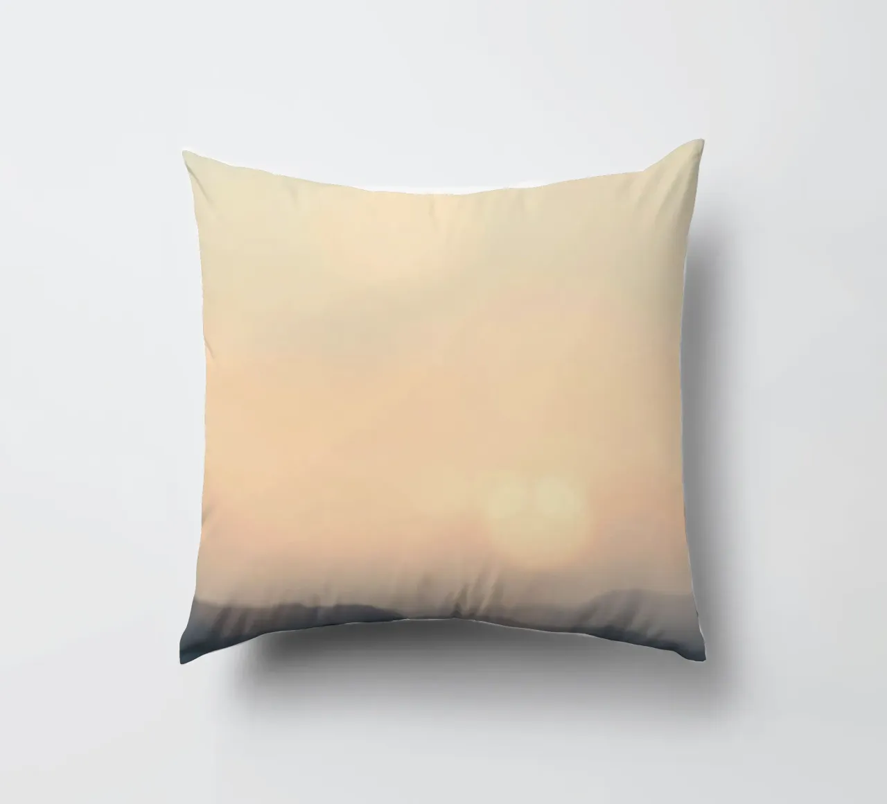 Sunset casting a warm glow over distant mountains and cloude decorative cushion by DesignDoodle