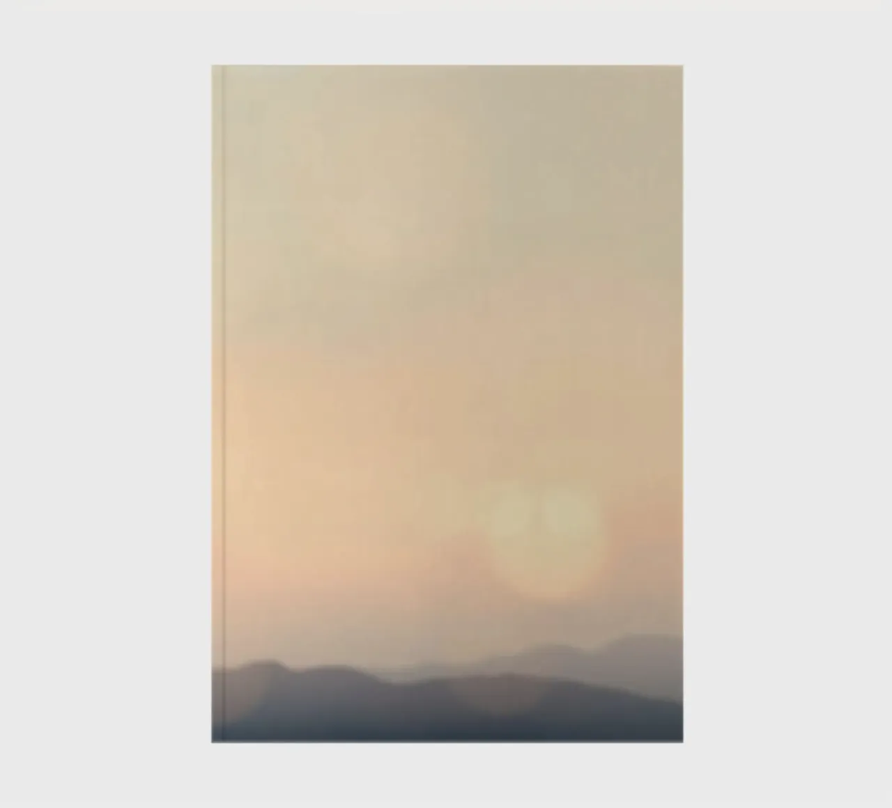 Sunset casting a warm glow over distant mountains and cloude notebook by DesignDoodle