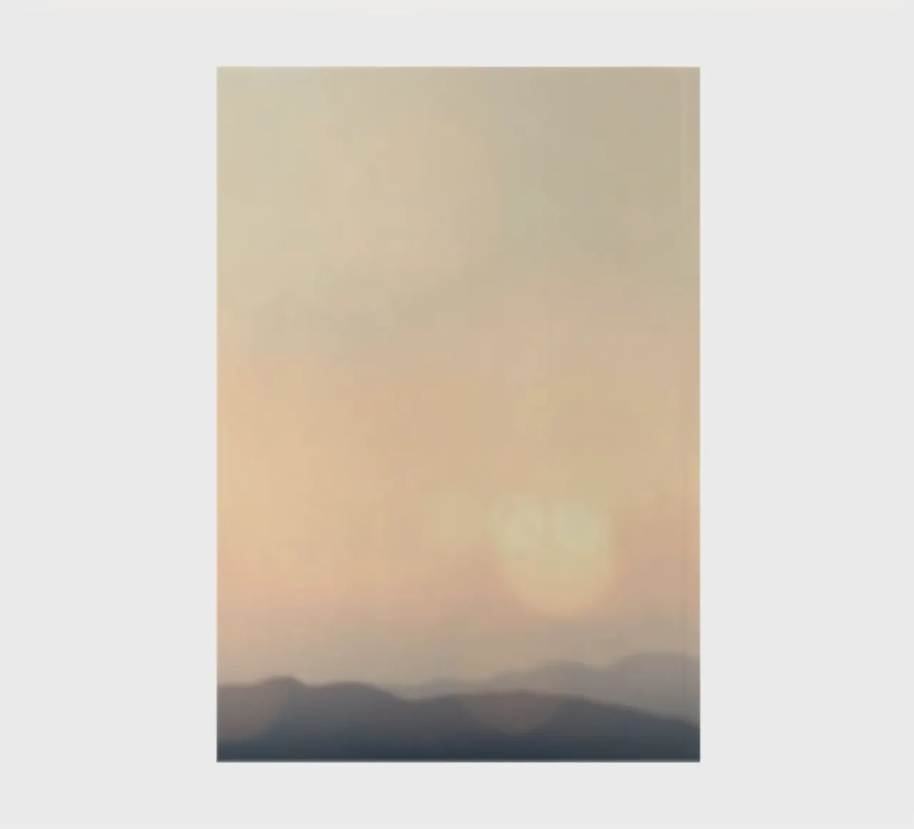 Sunset casting a warm glow over distant mountains and cloude notebook by DesignDoodle