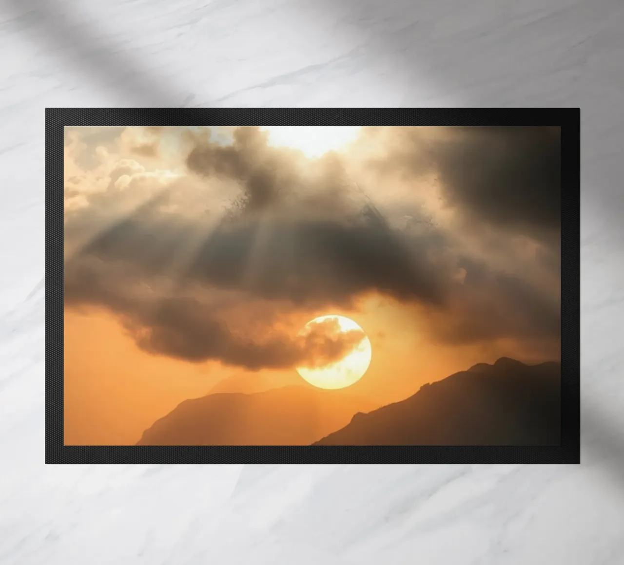 Atemberaubender Sonnenuntergang, der die Berggipfel unter einem dramatischen Fußmatte von DesignDoodle