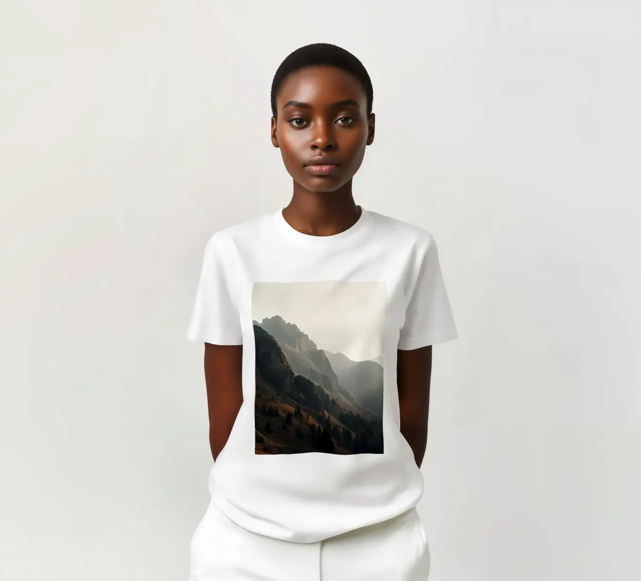Vue majestueuse sur les montagnes avec des sommets embrumés sous un doux soleil t-shirt de DesignDoodle