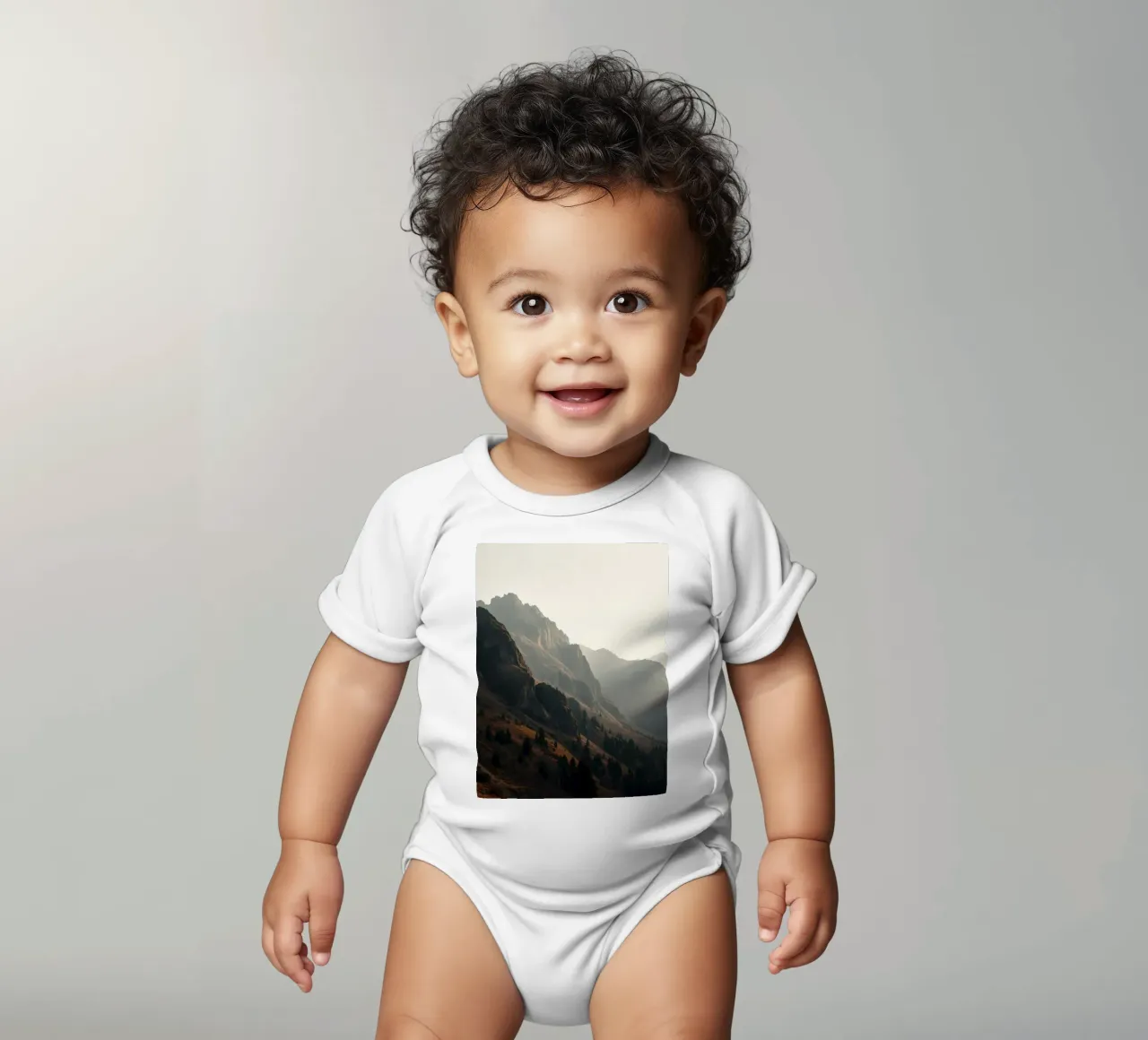Vue majestueuse sur les montagnes avec des sommets embrumés sous un doux soleil body bébé de DesignDoodle