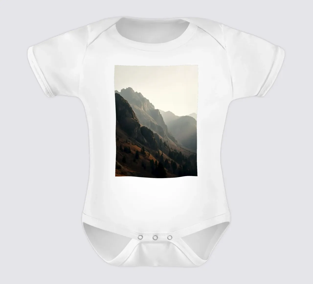 Vue majestueuse sur les montagnes avec des sommets embrumés sous un doux soleil body bébé de DesignDoodle