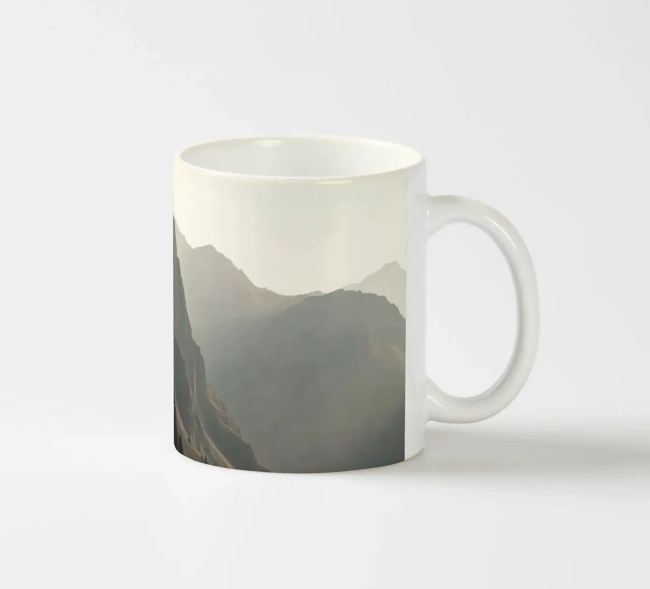 Majestätischer Bergblick mit nebligen Gipfeln im sanften Sonnenlicht Keramik Tasse von DesignDoodle
