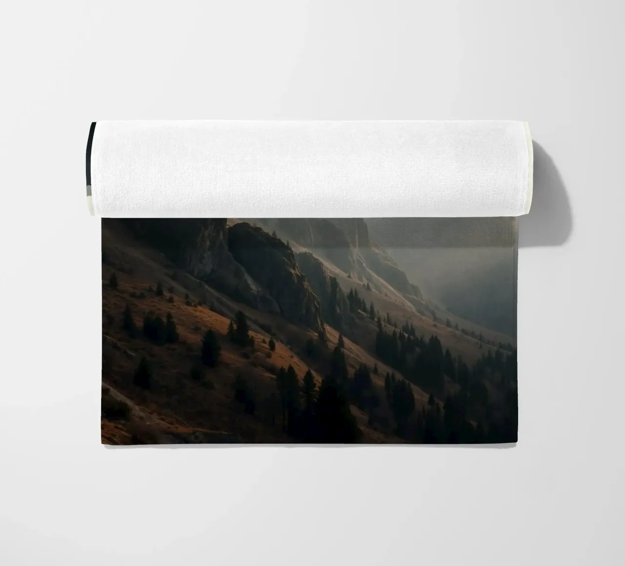 Vue majestueuse sur les montagnes avec des sommets embrumés sous un doux soleil serviette de plage de DesignDoodle