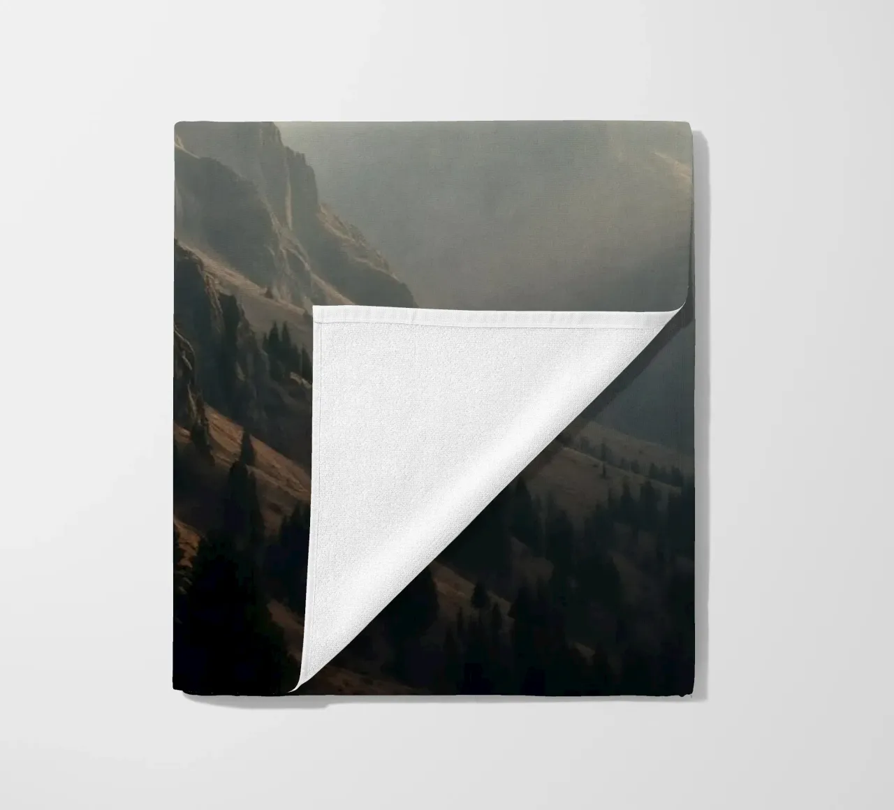 Vue majestueuse sur les montagnes avec des sommets embrumés sous un doux soleil serviette de plage de DesignDoodle