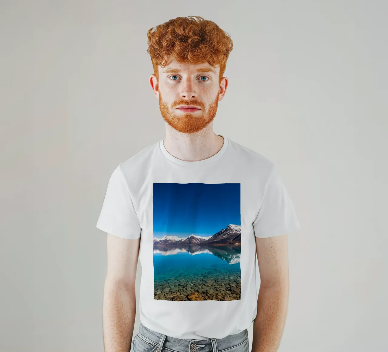 view of a serene lake surrounded by snow-capped mountains t-shirt by DesignDoodle