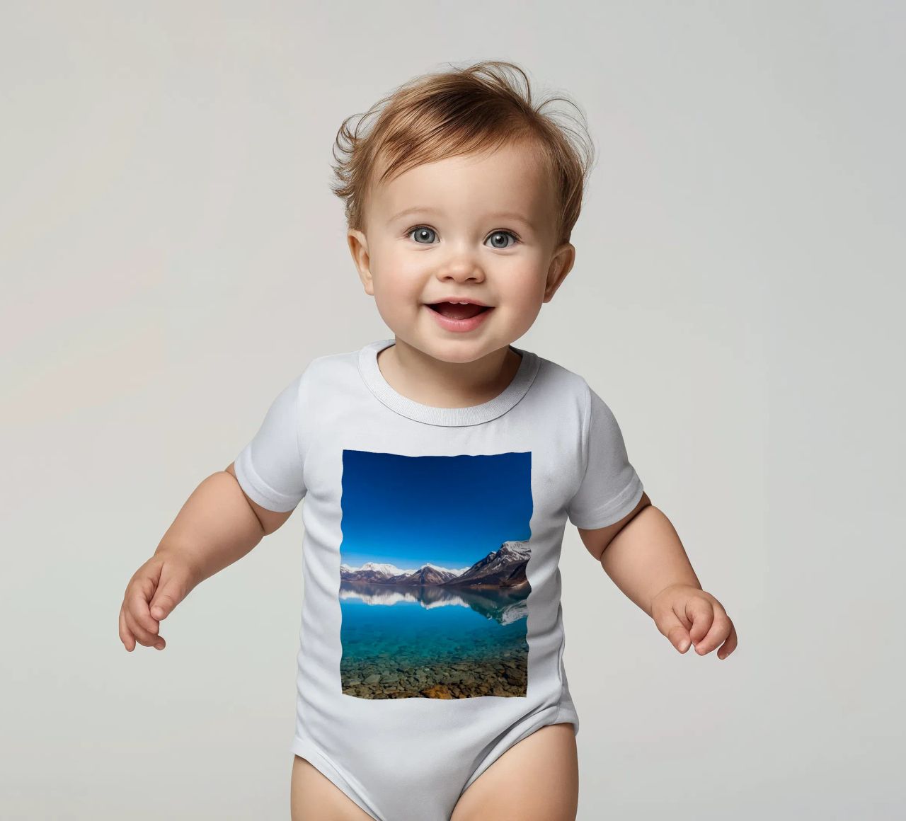 vue sur un lac serein entouré de montagnes enneigées body bébé de DesignDoodle