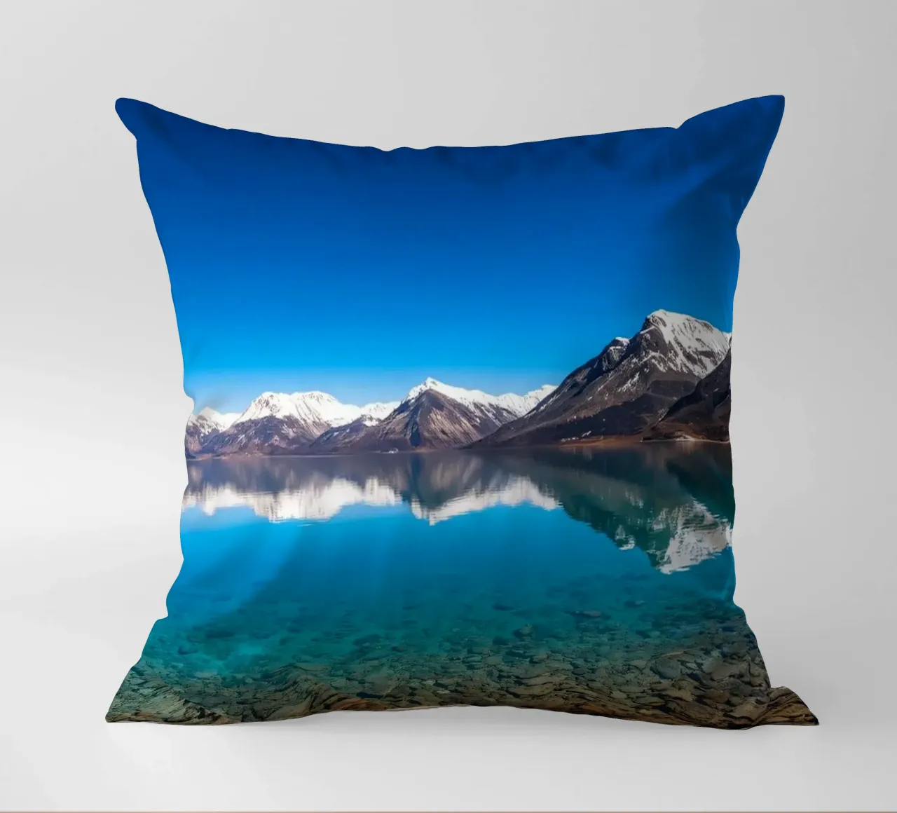 view of a serene lake surrounded by snow-capped mountains decorative cushion by DesignDoodle