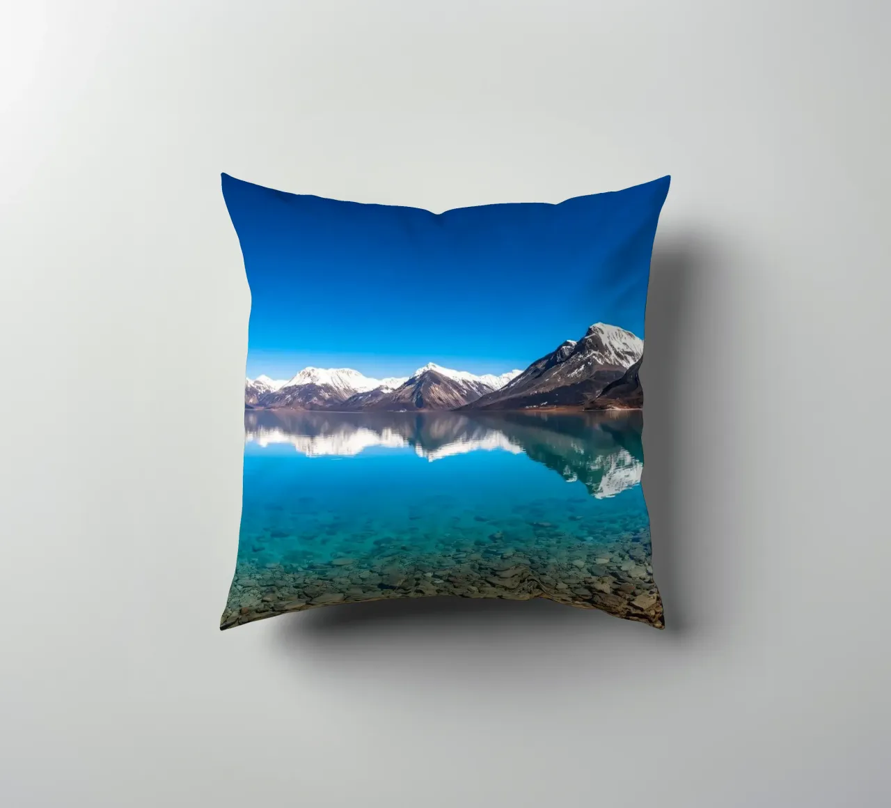 view of a serene lake surrounded by snow-capped mountains decorative cushion by DesignDoodle