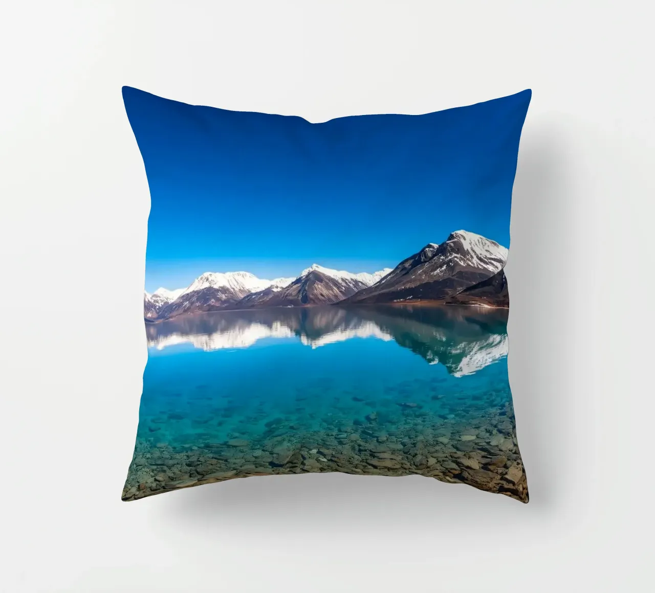 view of a serene lake surrounded by snow-capped mountains decorative cushion by DesignDoodle