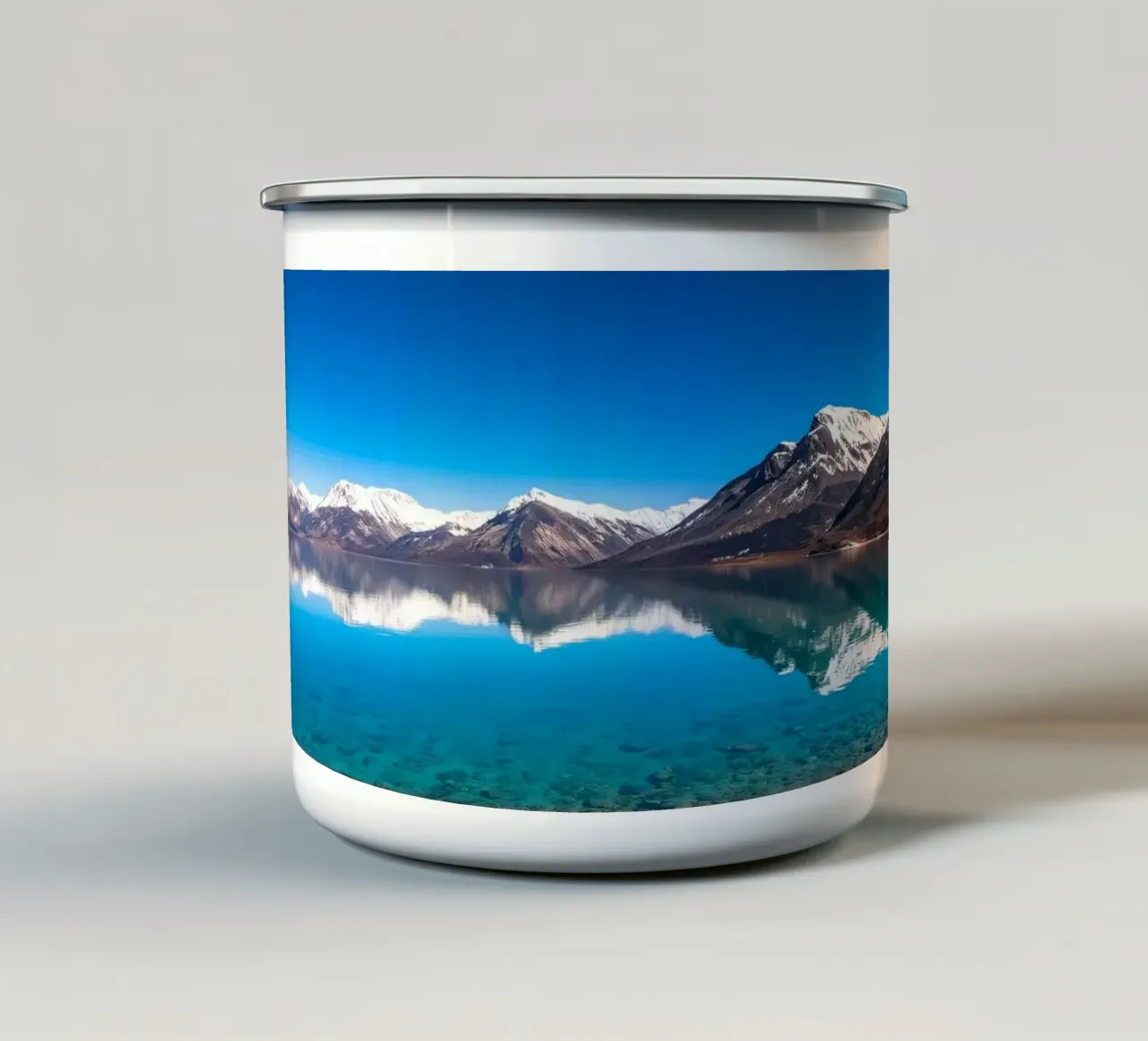 view of a serene lake surrounded by snow-capped mountains enamel mug by DesignDoodle