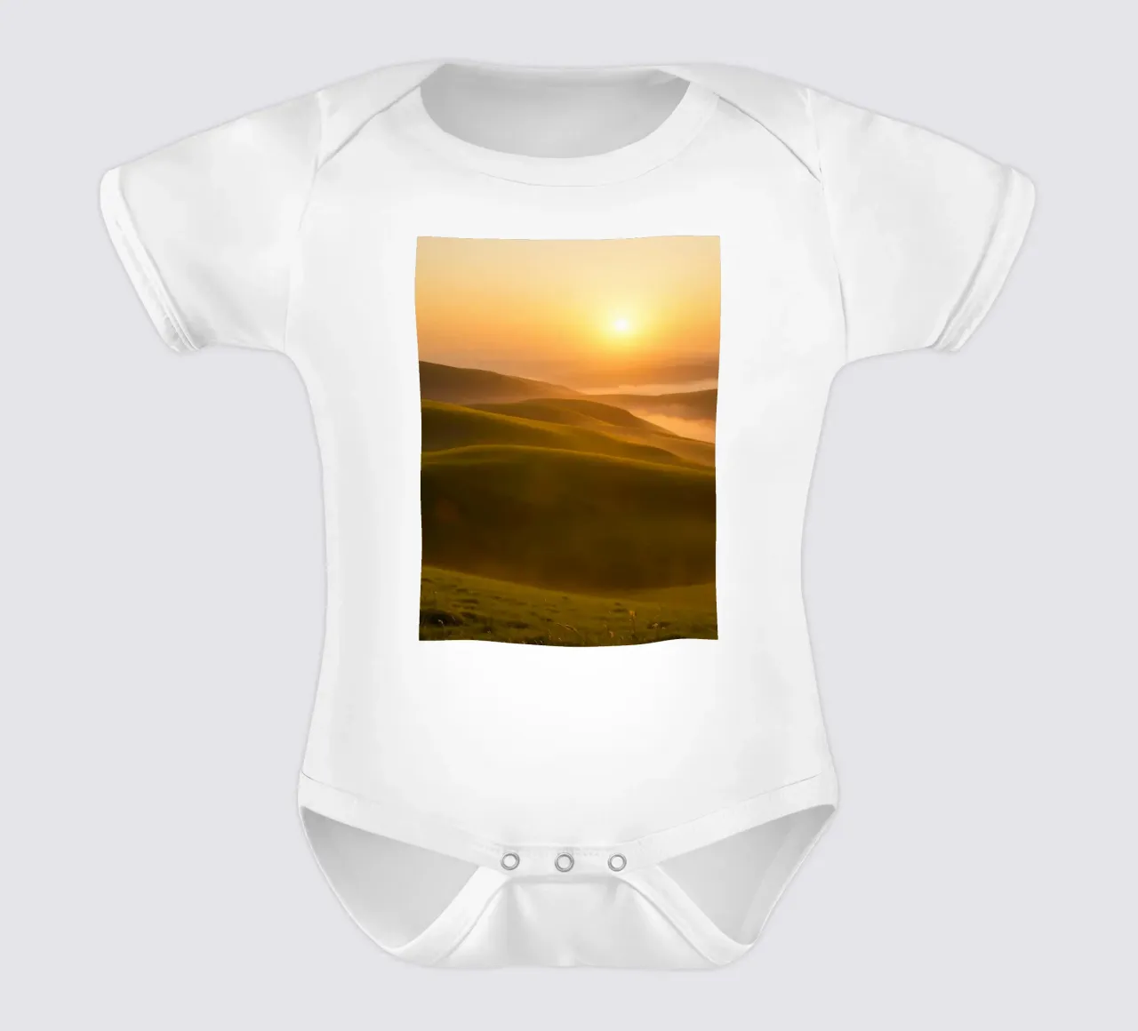 Sunset over rolling green hills with mist creating a serene short-sleeve baby romper by DesignDoodle