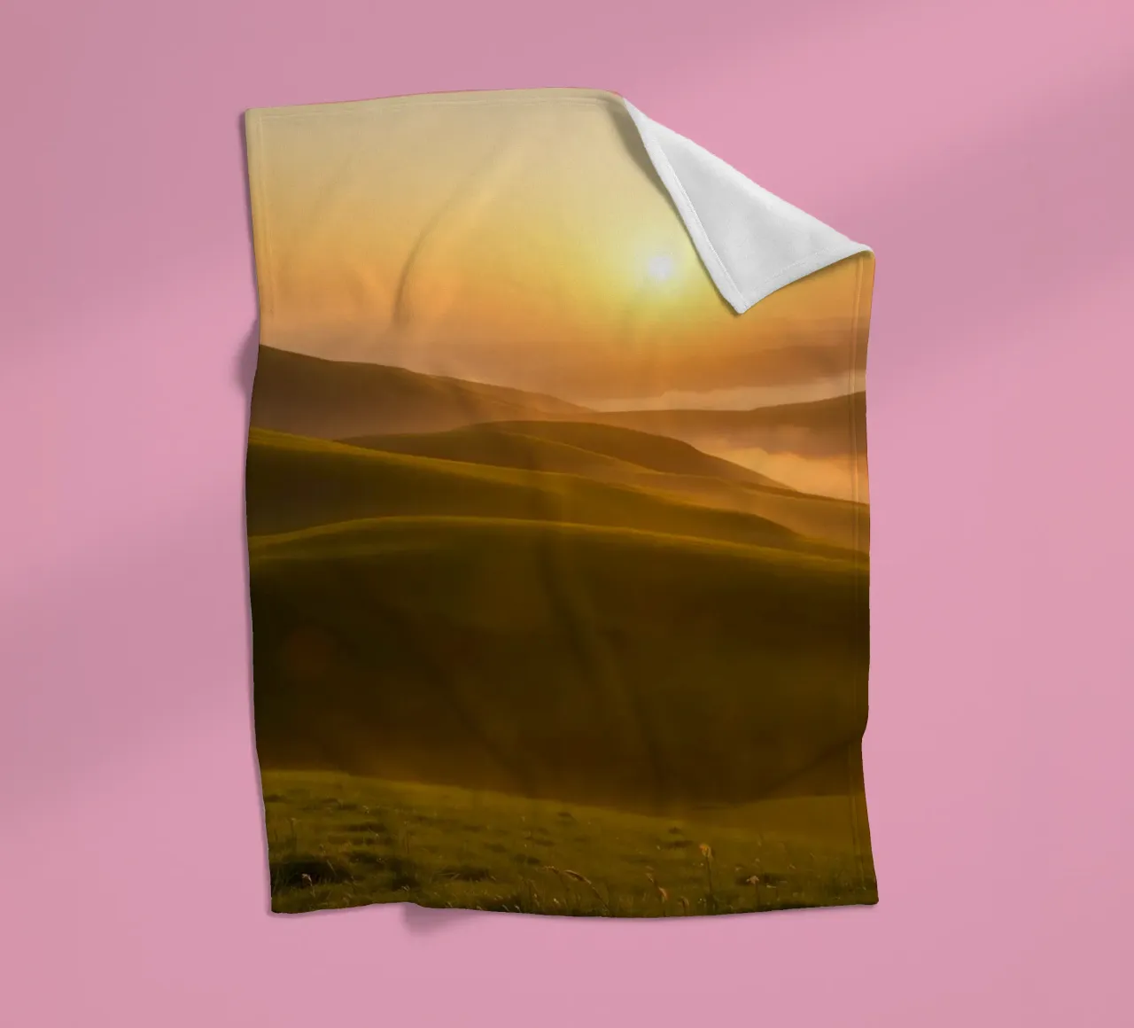 Sunset over rolling green hills with mist creating a serene fleece blanket by DesignDoodle