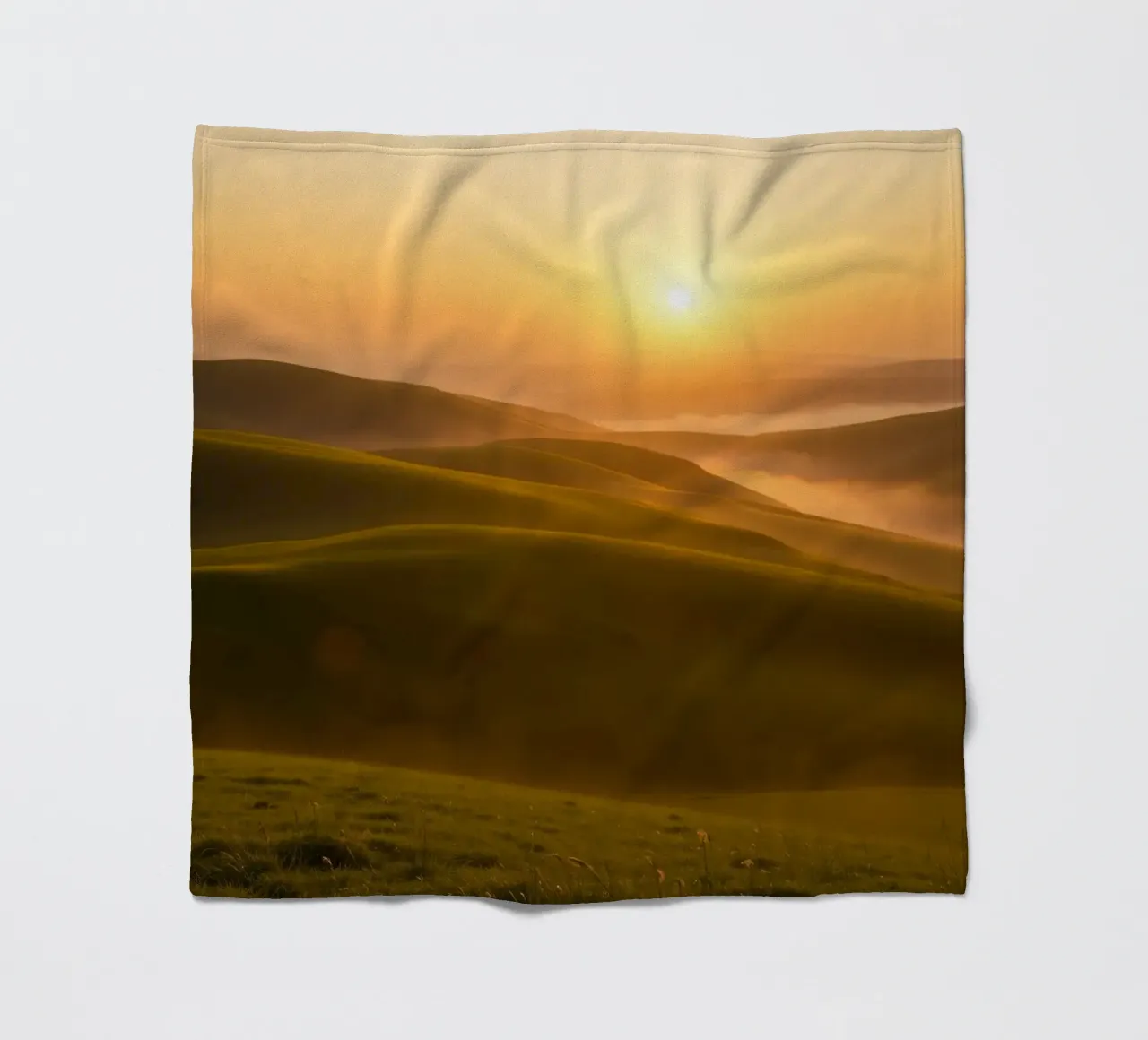Sunset over rolling green hills with mist creating a serene fleece blanket by DesignDoodle