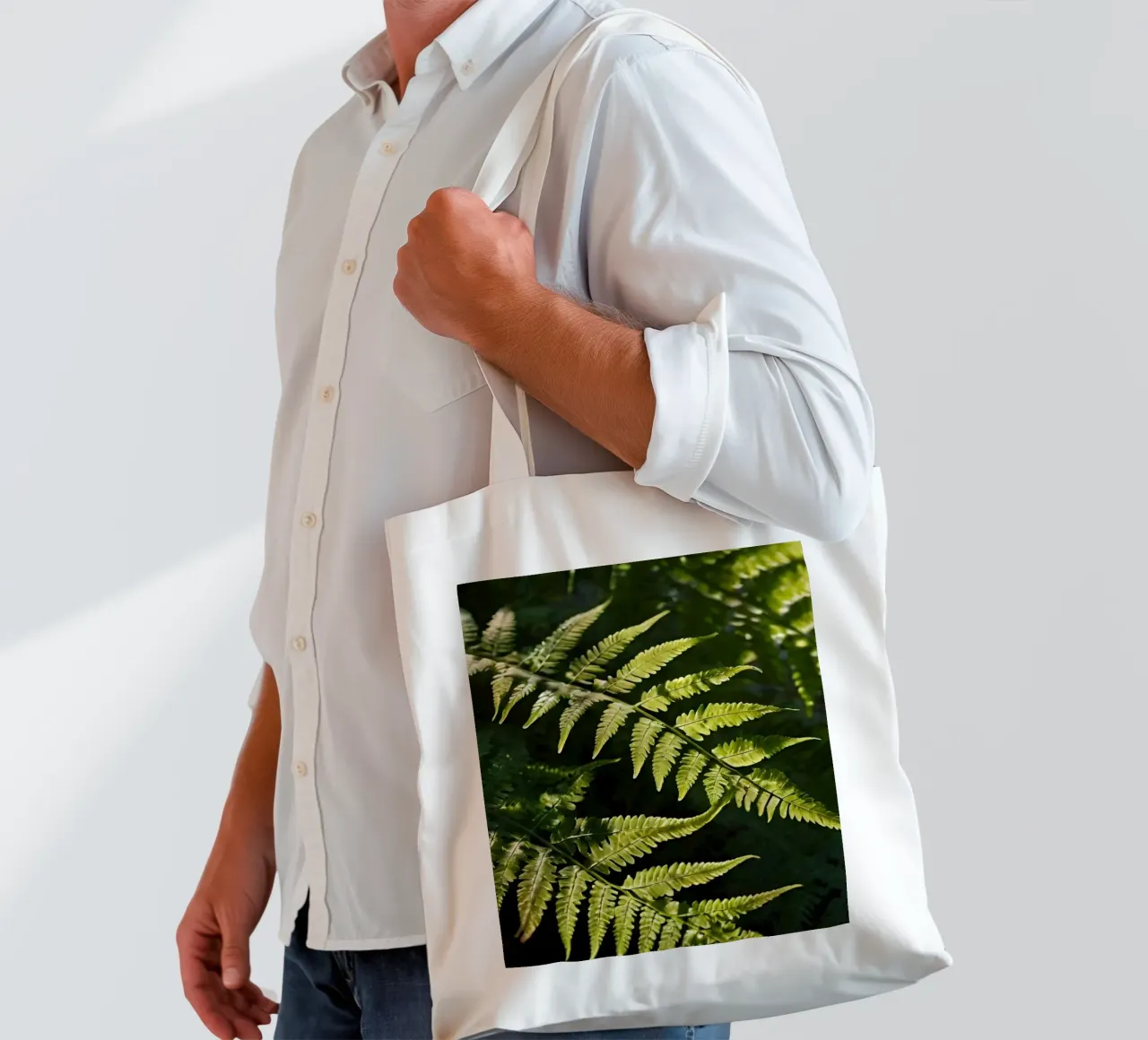 Sunlight filters through lush green ferns in a tranquil fore tote bag by DesignDoodle