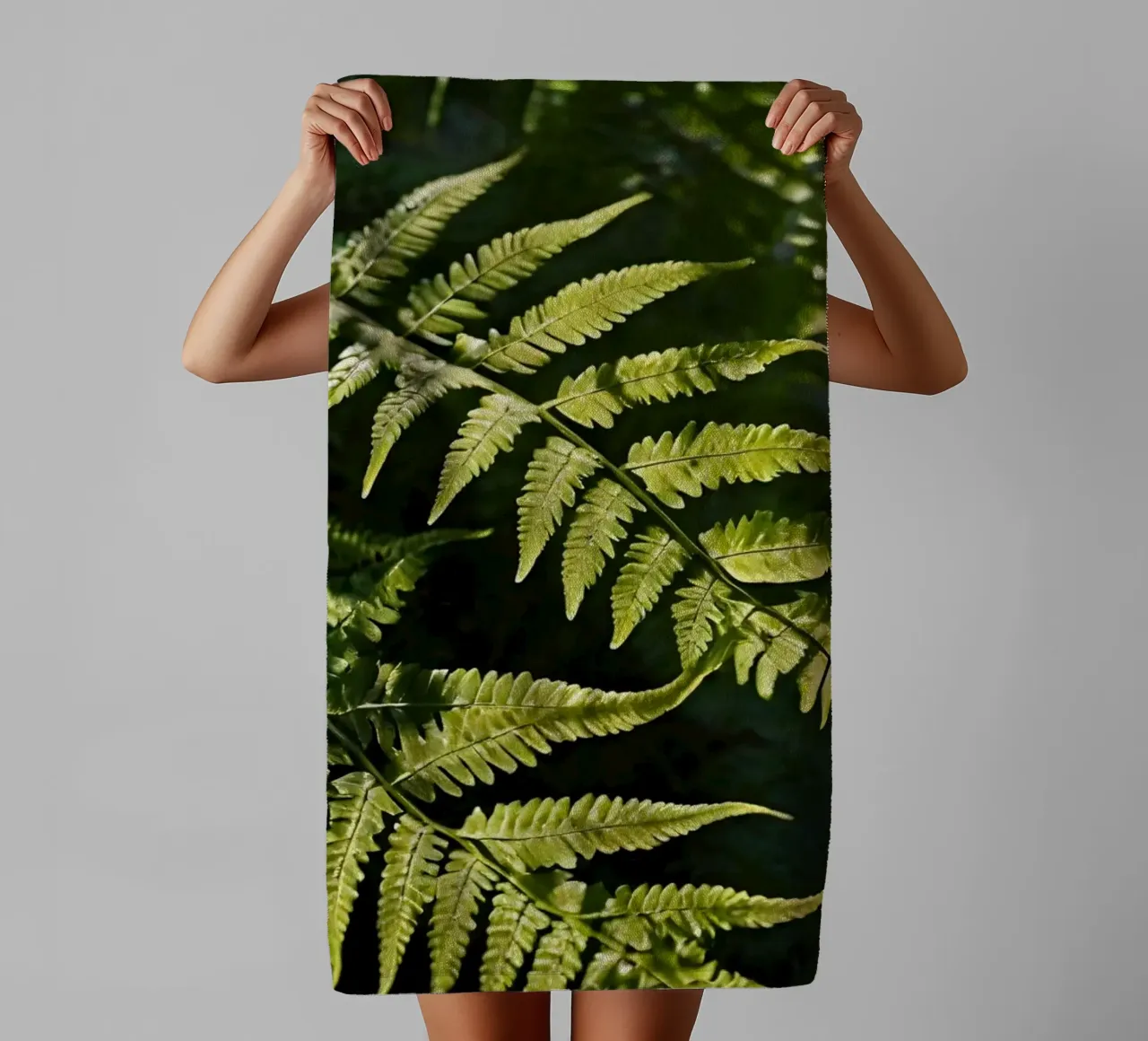 Sunlight filters through lush green ferns in a tranquil fore towel by DesignDoodle
