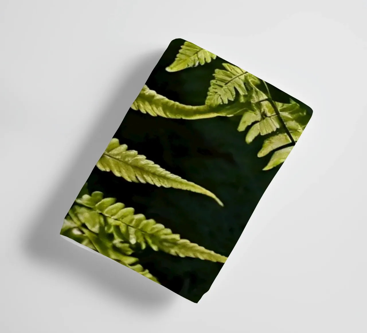 Sunlight filters through lush green ferns in a tranquil fore towel by DesignDoodle